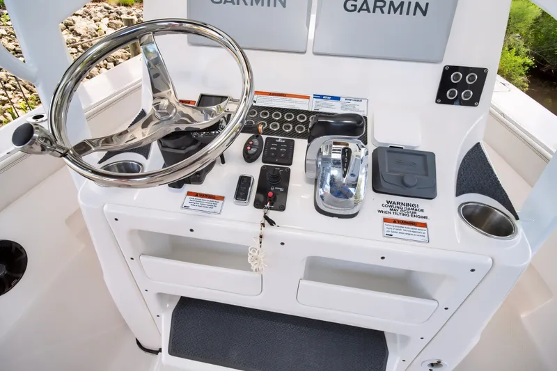 Slide: The Image of 2021 Blue Wave 2800 Makaira boat console with steering wheel and Garmin electronics. - 28