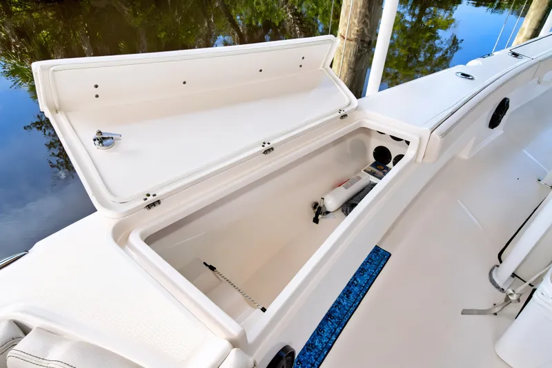 Slide: The Image of Open storage compartment on 2021 Blue Wave 2800 Makaira boat, featuring safety equipment. - 39