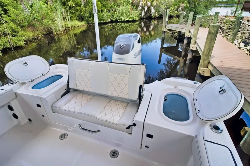 Slide: The Image of 2021 Blue Wave 2800 Makaira boat with seating and storage compartments by a dock. - 19