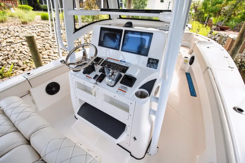 Slide: The Image of 2021 Blue Wave 2800 Makaira boat cockpit with dual screens and steering wheel. - 35