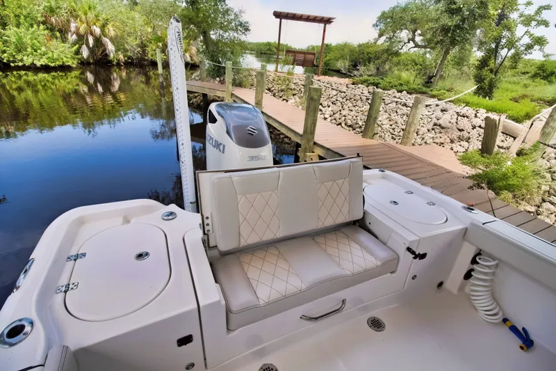Slide: The Image of 2021 Blue Wave 2800 Makaira boat interior with Suzuki engine, docked by a scenic river. - 13