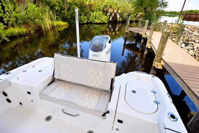 Slide: The Image of 2021 Blue Wave 2800 Makaira boat with Suzuki engine, docked by a serene river. - 14