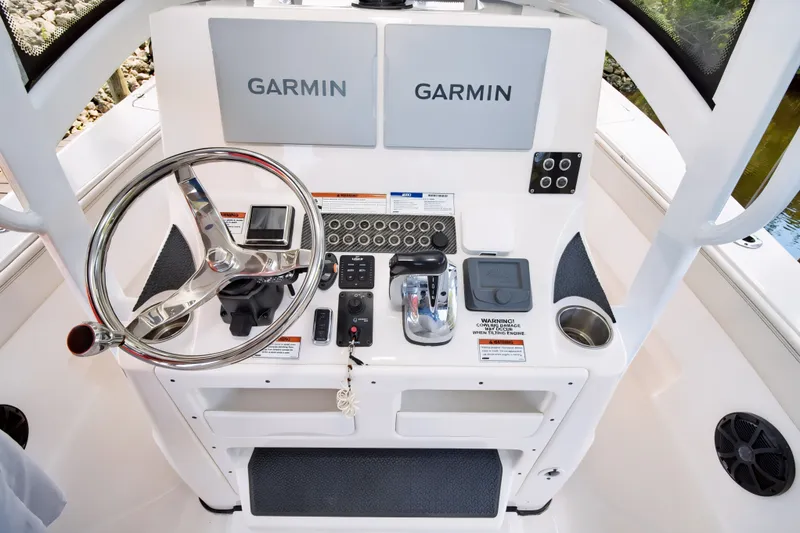 Slide: The Image of 2021 Blue Wave 2800 Makaira boat helm with Garmin navigation displays and steering wheel. - 27