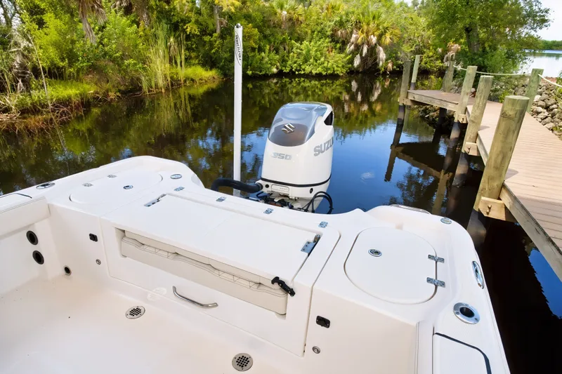 Slide: The Image of 2021 Blue Wave 2800 Makaira boat docked by lush greenery and calm water. - 18