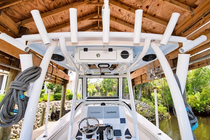 Slide: The Image of 2021 Blue Wave 2800 Makaira boat interior with Garmin electronics under wooden dock. - 23