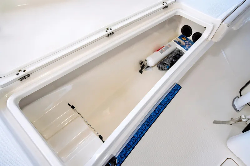 Slide: The Image of Open storage compartment in 2021 Blue Wave 2800 Makaira boat with safety equipment. - 40