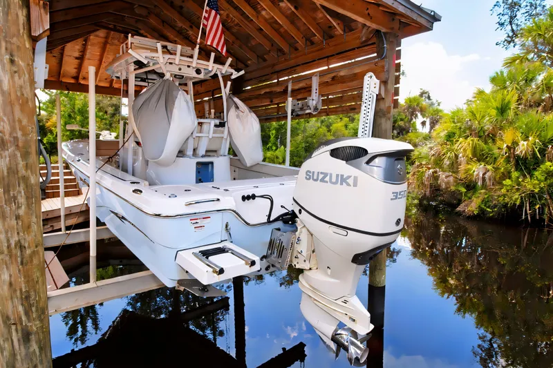 Slide: The Image of 2021 Blue Wave 2800 Makaira boat with Suzuki engine docked under a wooden shelter. - 4