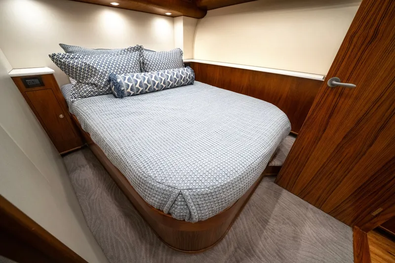 Slide: The Image of The cabin features a cozy bed with blue bedding, surrounded by wooden paneling. - 39