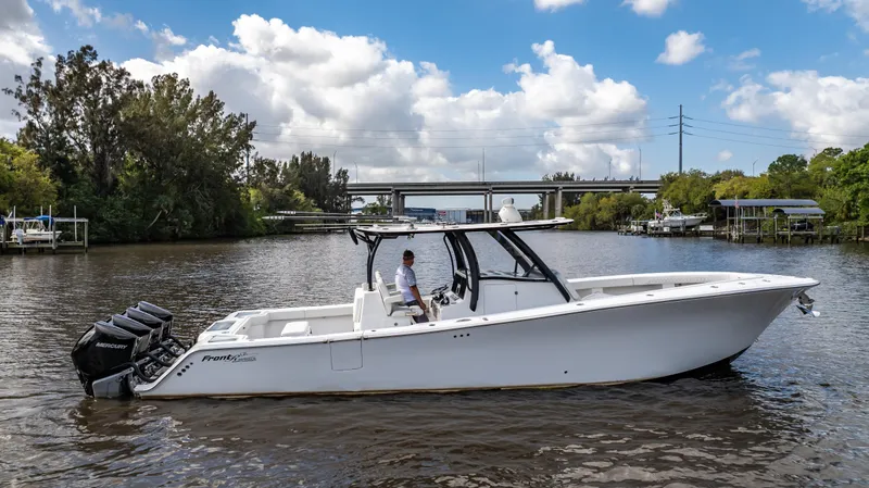 Slide: The Image of 2023 Front Runner 39 Center Console boat on a calm river under a blue sky. - 22