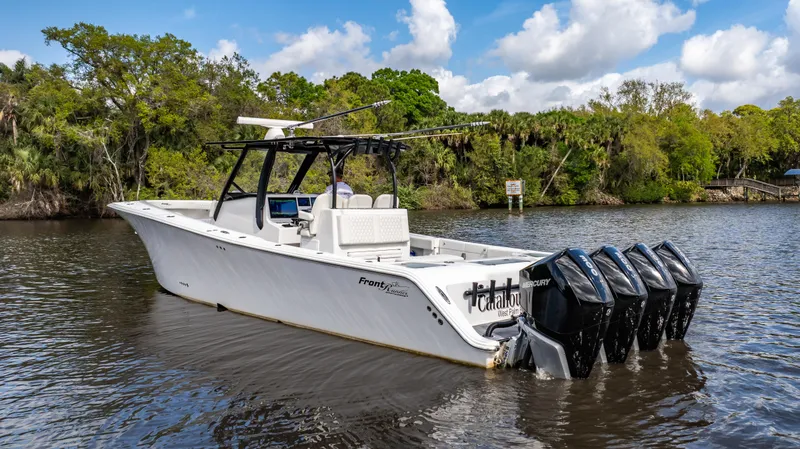 Slide: The Image of 2023 Front Runner 39 Center Console boat with multiple outboard engines on a scenic river. - 20