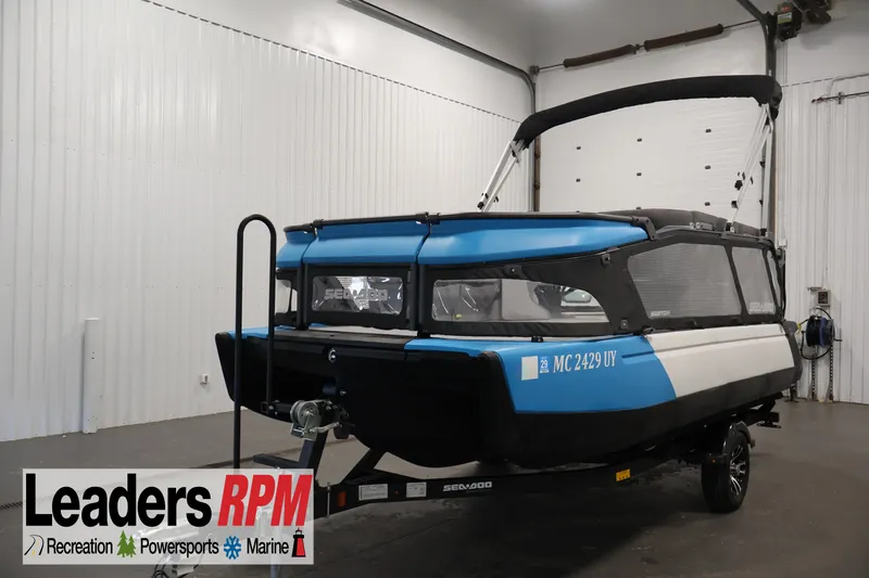 The Image of 2023 Sea-Doo Switch 16 pontoon boat in a showroom, featuring a blue and black design. - 0