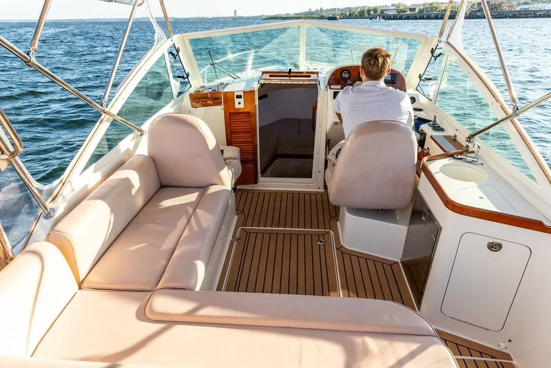 Slide: The Image of 2018 Hunt Yachts Harrier 26 interior with seating and helm, cruising on open water. - 16