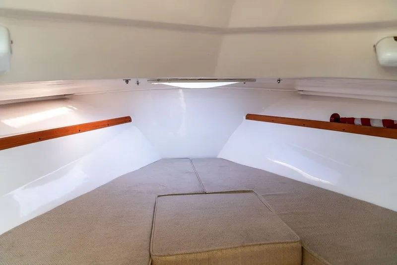Slide: The Image of 2018 Hunt Yachts Harrier 26 cabin interior with beige cushions and wooden accents. - 24