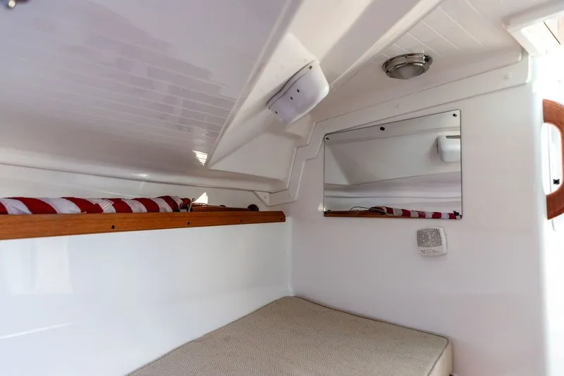 Slide: The Image of 2018 Hunt Yachts Harrier 26 cabin interior with bed, mirror, and striped cushion. - 26