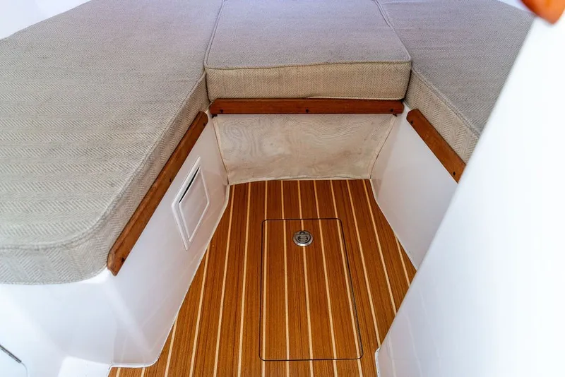 Slide: The Image of 2018 Hunt Yachts Harrier 26 interior with cushioned seating and wooden flooring. - 25