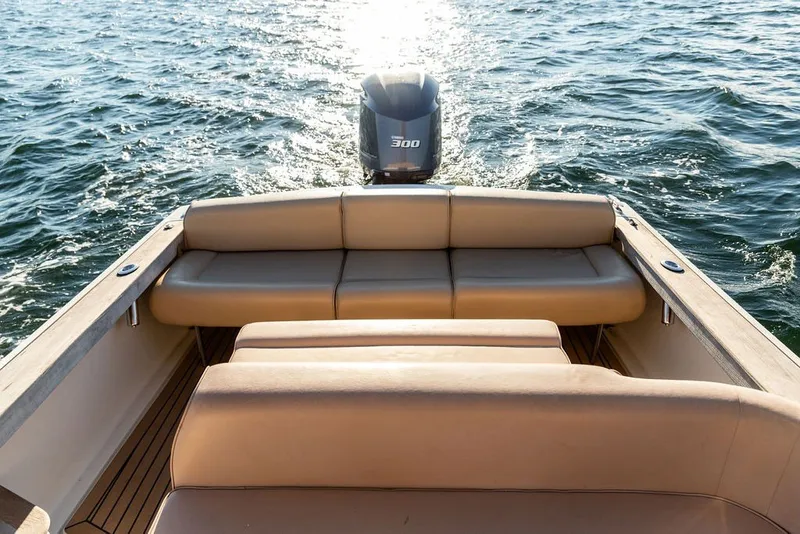 Slide: The Image of 2018 Hunt Yachts Harrier 26 with tan seating and powerful outboard motor on open water. - 22