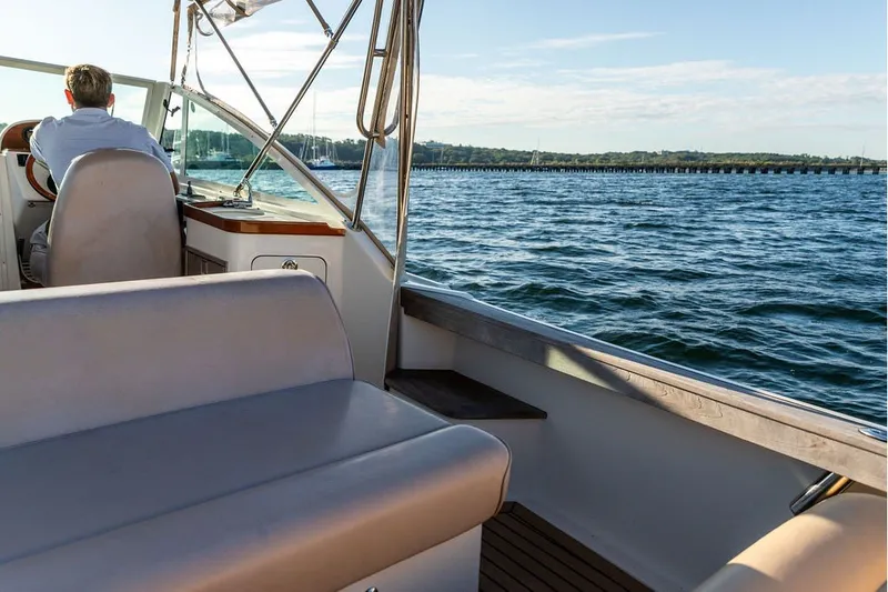 Slide: The Image of 2018 Hunt Yachts Harrier 26 cruising on open water with scenic shoreline view. - 20