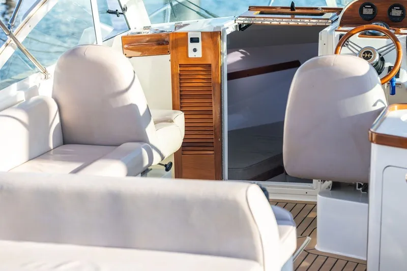 Slide: The Image of Interior of 2018 Hunt Yachts Harrier 26, featuring plush seating and wooden accents. - 14