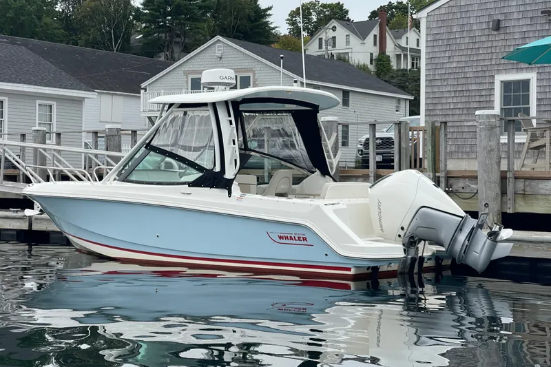 Slide: The Image of 2023 Boston Whaler 240 Vantage boat docked at a marina, showcasing sleek design. - 29