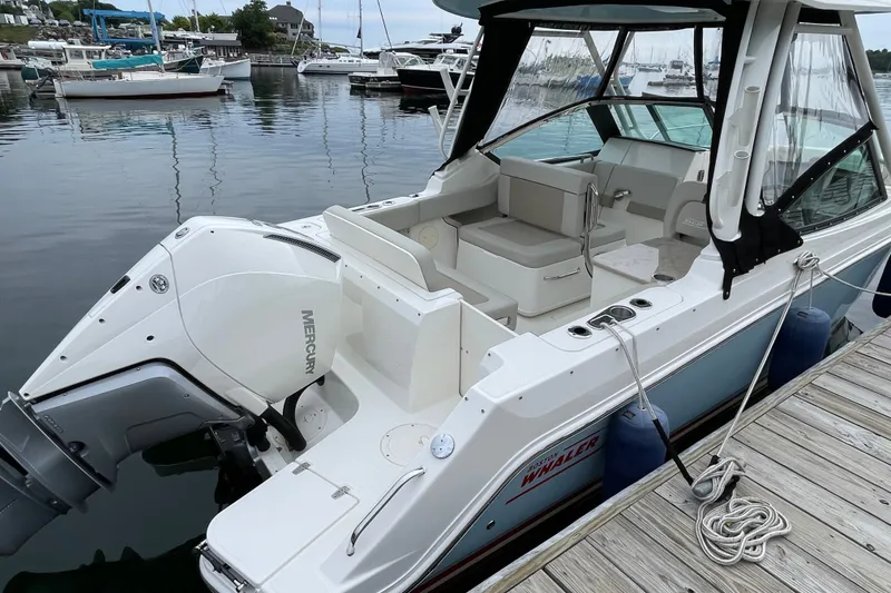 Slide: The Image of 2023 Boston Whaler 240 Vantage docked, showcasing spacious seating and Mercury outboard engine. - 17