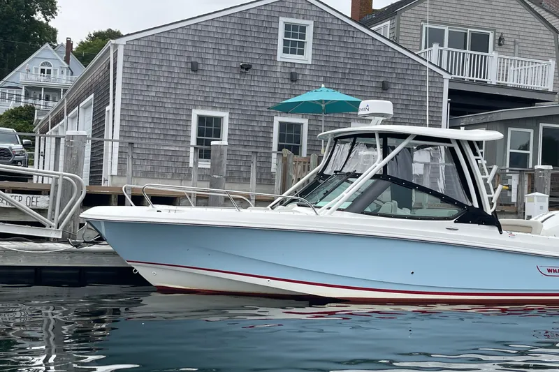 Slide: The Image of 2023 Boston Whaler 240 Vantage boat docked near coastal house. - 35