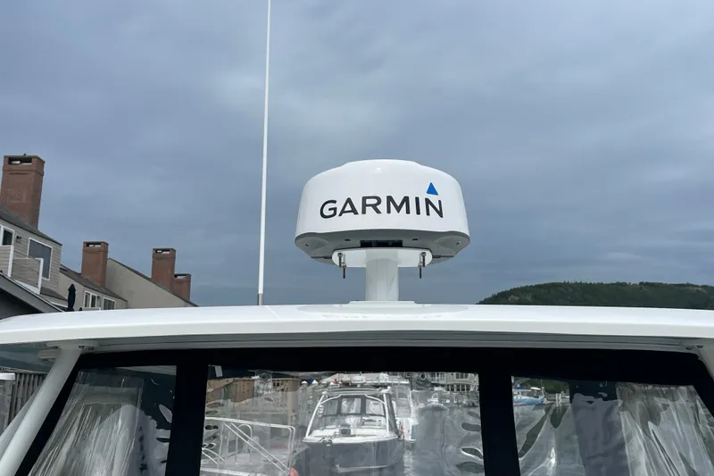 Slide: The Image of 2023 Boston Whaler 240 Vantage with Garmin radar, docked under cloudy skies. - 68