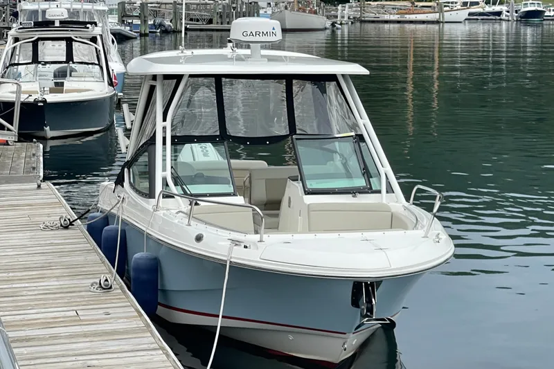 Slide: The Image of 2023 Boston Whaler 240 Vantage docked at marina, featuring Garmin equipment. - 9