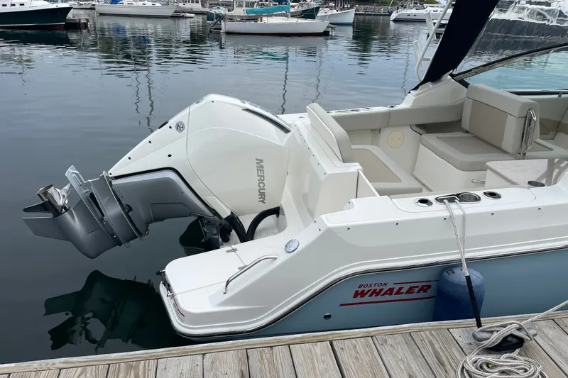 Slide: The Image of 2023 Boston Whaler 240 Vantage boat docked, featuring a Mercury outboard motor. - 14