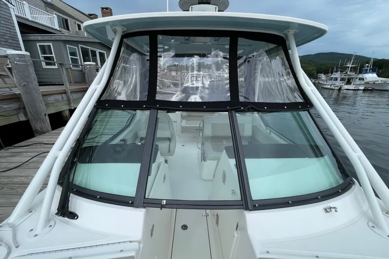 Slide: The Image of 2023 Boston Whaler 240 Vantage boat docked, showcasing cockpit and windshield. - 70