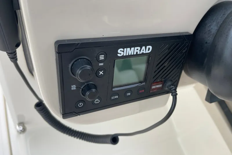 Slide: The Image of Simrad marine radio on 2023 Boston Whaler 240 Vantage boat dashboard. - 59