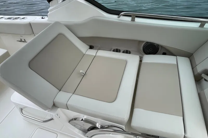 Slide: The Image of 2023 Boston Whaler 240 Vantage boat interior with cushioned seating and cup holders. - 45