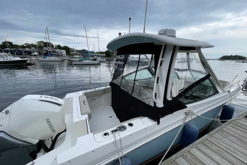 Slide: The Image of 2023 Boston Whaler 240 Vantage docked, featuring Mercury engine and enclosed cockpit. - 74