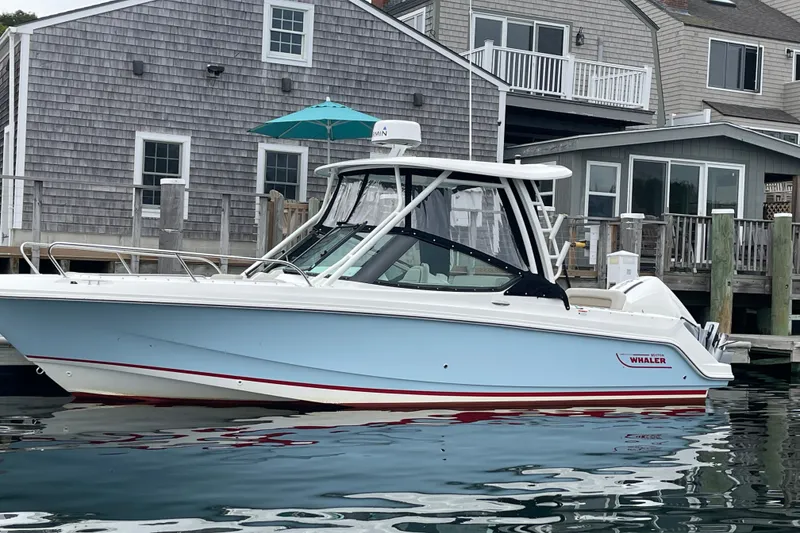 Slide: The Image of 2023 Boston Whaler 240 Vantage boat docked near coastal homes. - 34