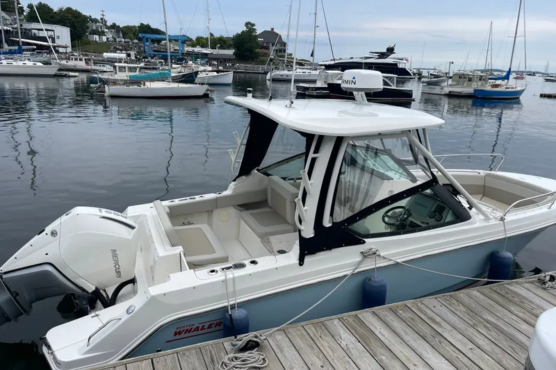 Slide: The Image of 2023 Boston Whaler 240 Vantage docked at marina with other boats. - 6