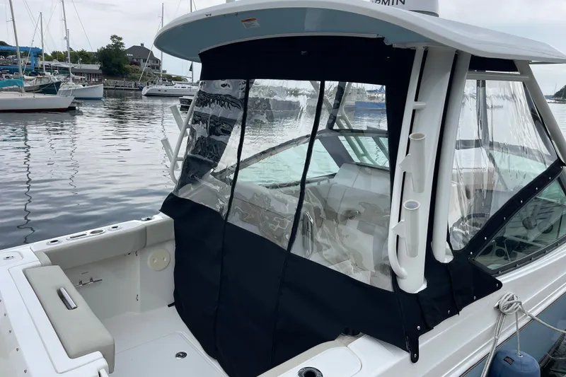 Slide: The Image of 2023 Boston Whaler 240 Vantage boat with protective canopy docked in marina. - 75