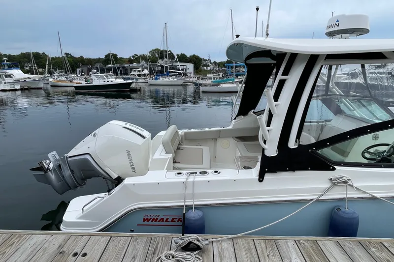 Slide: The Image of 2023 Boston Whaler 240 Vantage docked at marina with Mercury outboard engine. - 20