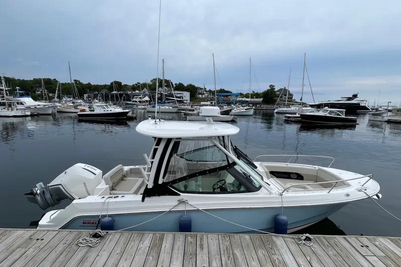 Slide: The Image of 2023 Boston Whaler 240 Vantage docked in a marina with other boats. - 3