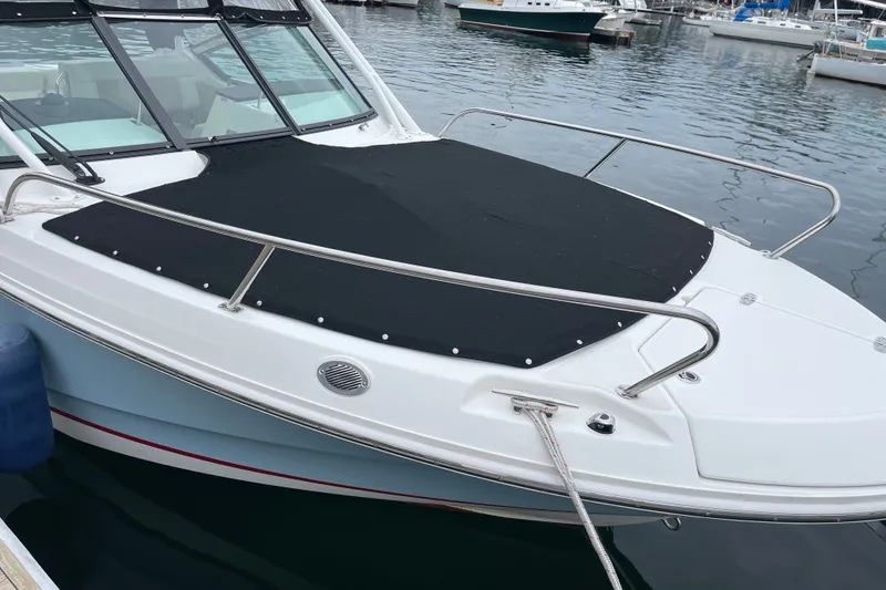 Slide: The Image of 2023 Boston Whaler 240 Vantage boat docked with black cover on bow. - 81
