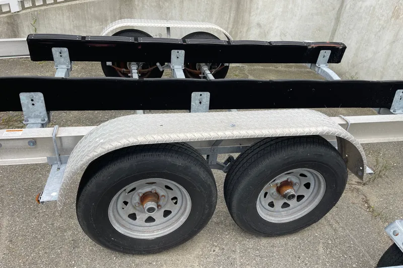 Slide: The Image of Boat trailer for 2023 Boston Whaler 240 Vantage, featuring dual wheels and metal frame. - 83