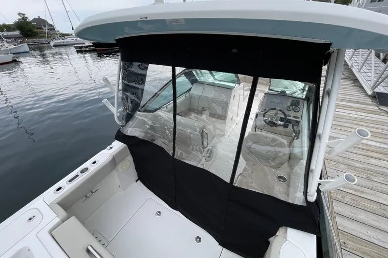 Slide: The Image of 2023 Boston Whaler 240 Vantage boat docked, featuring covered cockpit and sleek design. - 76