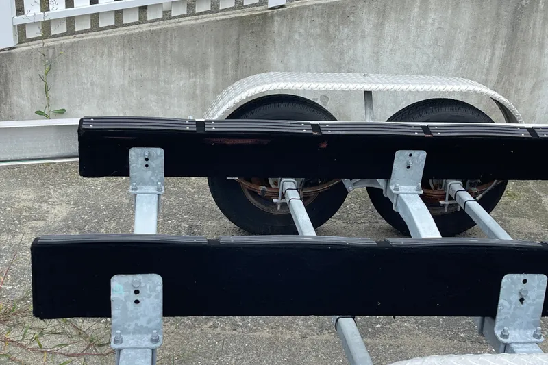 Slide: The Image of Trailer for 2023 Boston Whaler 240 Vantage boat, featuring dual wheels and sturdy frame. - 84