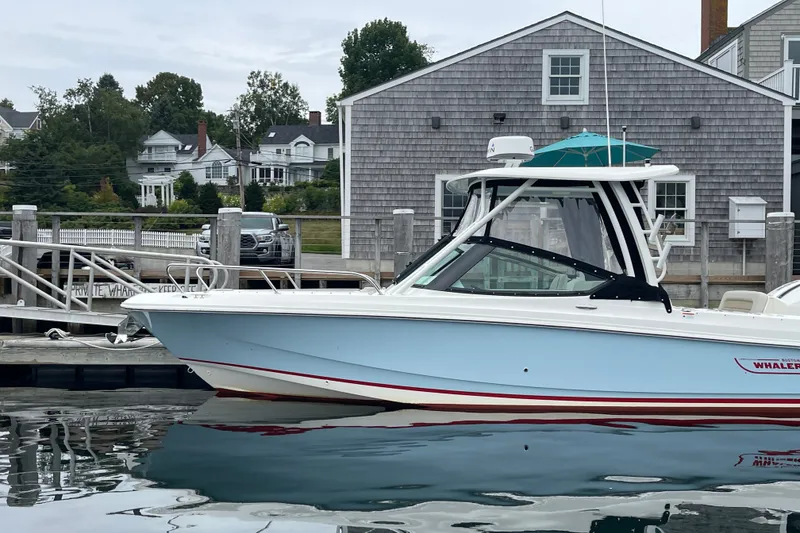 Slide: The Image of 2023 Boston Whaler 240 Vantage boat docked near coastal buildings. - 27