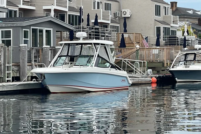 Slide: The Image of 2023 Boston Whaler 240 Vantage docked near waterfront homes. - 22