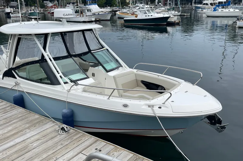 Slide: The Image of 2023 Boston Whaler 240 Vantage docked in a marina, showcasing sleek design and modern features. - 4