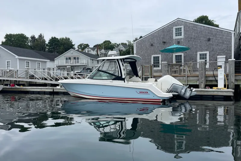Slide: The Image of 2023 Boston Whaler 240 Vantage docked by waterfront homes. - 28