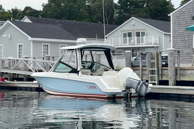 Slide: The Image of 2023 Boston Whaler 240 Vantage boat docked near waterfront houses. - 33