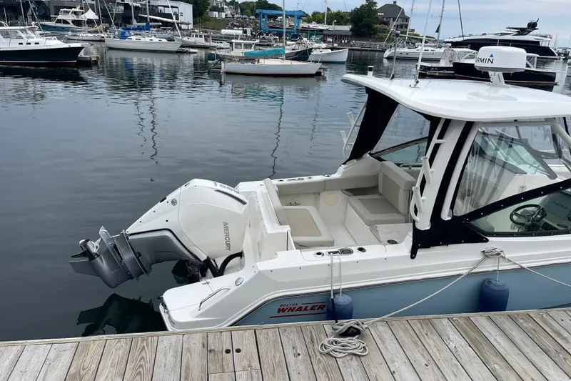 Slide: The Image of 2023 Boston Whaler 240 Vantage docked at marina with Mercury outboard engine. - 5