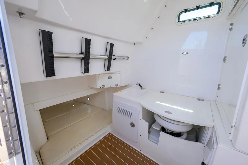 Slide: The Image of Interior of 2018 Everglades 355 Center Console boat, featuring a compact bathroom area. - 52