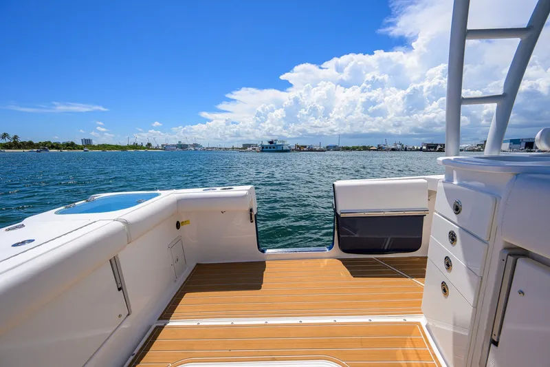 Slide: The Image of 2018 Everglades 355 Center Console boat with teak deck, overlooking a sunny seascape. - 41