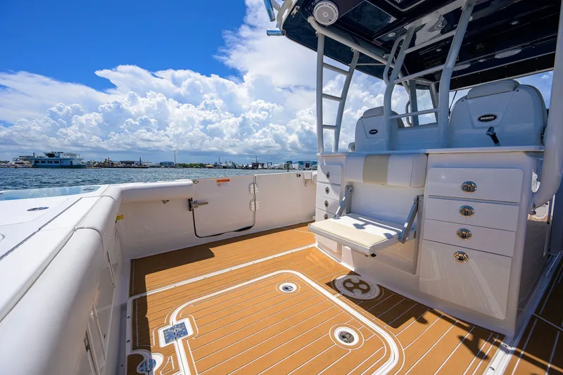 Slide: The Image of 2018 Everglades 355 Center Console boat with spacious deck and seating, under a bright sky. - 39